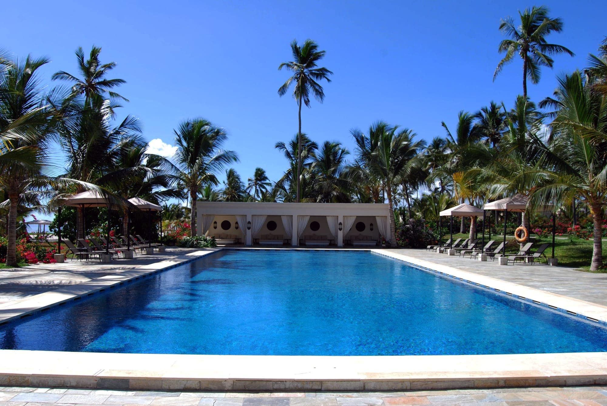 A palm-lined hotel pool beside the beach in Zanzibar
