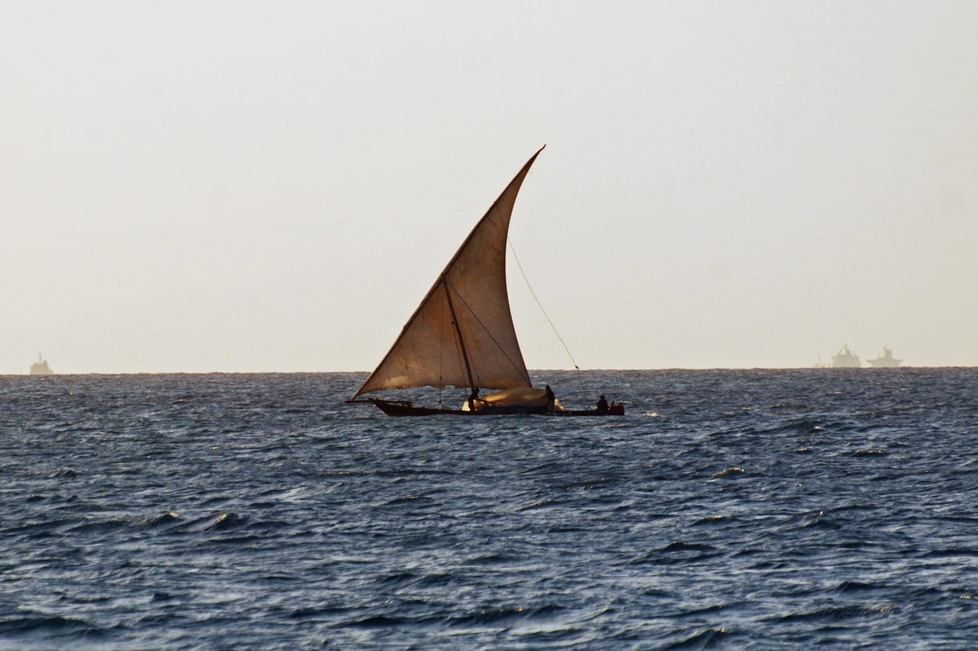 A traditional wooden dhow under full sail off Zanzibar